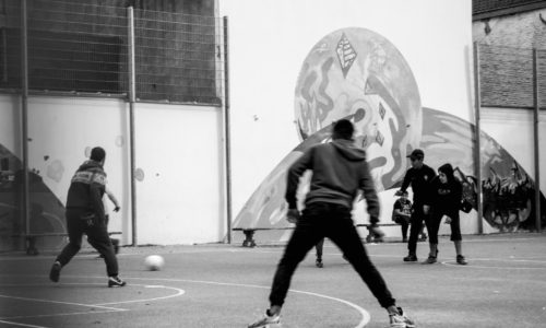 des jeunes jouent au foot sur un terrain